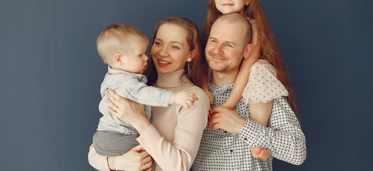 A joyful family portrait showcasing parents and their two children, expressing love and togetherness.