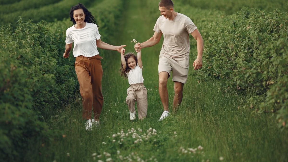 Joyful family enjoying a fun day outdoors in a green field, epitomizing togetherness and happiness.